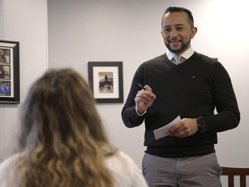 An admissions counselor standing with pen and paper in front of a student